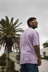 Remera blanca de algodón con cuello redondo y estampado circular en el frente con diseño abstracto en tonos grises.