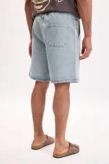 Bermuda de jean en azul medio con lavado suave, bolsillos clásicos y corte por encima de la rodilla.