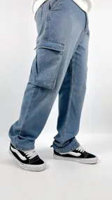 Pantalón de jean celeste, corte amplio, con bolsillos cargo laterales y traseros.