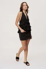 Minifalda blanca de denim con tiro medio, diseño de cinco bolsillos y detalles de estrellas metálicas en los laterales.