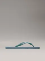 Chancletas Calvin Klein color celeste con logo de la marca en la tira.