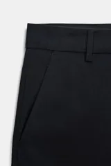 Pantalón de tiro medio confeccionado en lana 100%, con corte de pierna recta y bajo con vuelta. Presenta cintura con trabillas, cierre frontal con cremallera, botón y ganchos metálicos, además de bolsillos laterales y traseros.