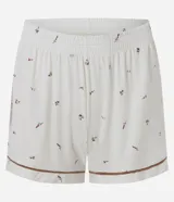 Pijama corto de dos piezas confeccionado en viscolycra blanca con estampado floral y vivo en contraste. Incluye una camisa de manga corta con cuello solapa y cierre frontal de botones, y un short con cintura elástica.