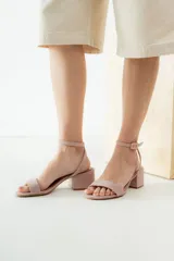Sandalias de cuero color suela con taco cuadrado bajo y tira ajustable con hebilla en el tobillo.