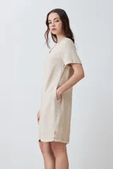 Vestido corto color beige melange, de lino, con cuello en V y mangas cortas. Presenta pespuntes verticales en contraste.
