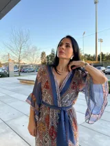 Vestido largo de manga ancha y escote en V, con cinturón a juego, confeccionado en tela estampada con motivos cachemir en tonos azules, rojos y ocres.