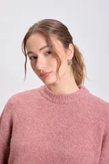 Buzo de punto en color rosa viejo, de cuello redondo, manga larga y diseño holgado con puños y ruedo acanalados.