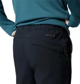 Pantalon de senderismo color negro, con cintura parcialmente elástica, cinturón integrado, múltiples bolsillos funcionales y refuerzo en la entrepierna.