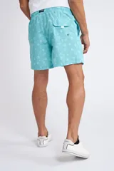 Short de baño con cintura elástica y cordón ajustable, confeccionado en tela ligera de secado rápido. Presenta un estampado botánico integral en tonos amarillos, blancos y azules, con dos bolsillos delanteros y uno posterior.