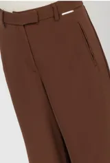 Pantalon de vestir color marron, de corte recto y tiro alto, con cintura estructurada y cierre frontal. Presenta una silueta amplia y fluida.