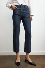 Jeans de mezclilla azul claro, tiro medio, corte recto y ligeramente acampanado en el bajo. Presenta cinco bolsillos y cierre frontal con cremallera y botón metálico.