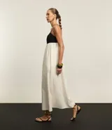 Vestido evasé midi de viscolino, con escote recto y breteles finos. Diseño bicolor con busto negro y falda blanca.