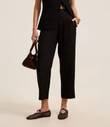 Pantalón de vestir negro, de corte recto, con trabillas en la cintura y pliegues.