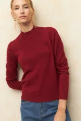 Polera color borgoña de tejido de punto con cuello alto y mangas largas.