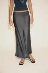 Falda midi de corte recto, color gris oscuro metalizado, confeccionada en tejido satinado con tiro alto y cintura elástica.
