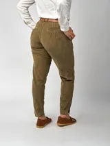 Pantalón de pana negro de corte recto, con bolsillos laterales y traseros. Se ajusta a la cintura con cinturón de cuero negro.