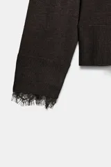 Jersey de punto fino con escote en pico y manga larga. Presenta detalles de encaje a tono en el escote y en los puños.