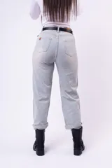 Pantalón de jean corte wide leg en tono celeste claro, con detalle de pequeñas incrustaciones de strass distribuidas por toda la prenda. Presenta ruedos doblados y cierre frontal con botón.