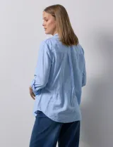 Camisa de lino color beige de la marca Dash, con cuello camisero, cierre frontal con botones, manga larga regulable con presilla y un bolsillo aplicado en el pecho.