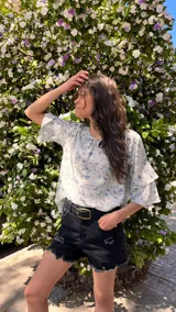 Blusa estampada con motivo floral y mangas cortas con doble volado.