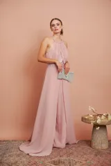 Mono de fiesta color rosa pálido, con cuello halter, cuerpo drapeado con lentejuelas y pantalón palazzo. Incluye cinturón con lentejuelas.