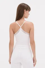 Musculosa blanca de breteles finos y corte corto, con detalle de encaje en el escote en V.