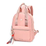 Mochila urbana Las Oreiro de color rosado, confeccionada en material sintético con acabado satinado. Presenta un compartimento principal con cierre, un bolsillo frontal con cierre, correas ajustables para los hombros y manijas superiores. Incluye un detalle de llavero con borlas decorativas y el logo metálico de la marca en el frente.