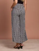 Pantalón fluido de corte recto y largo midi, con estampado abstracto en tonos azul, negro y crema. Presenta cintura elastizada en la parte posterior y bolsillos laterales delanteros.