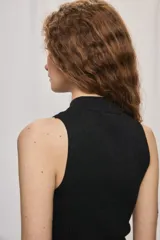 Top negro de tejido de punto acanalado, sin mangas, con cuello alto y silueta ajustada al cuerpo, con un sutil acabado brillante.