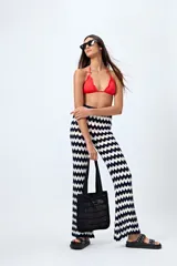 Pantalón tejido con motivo zigzag en blanco y negro, de corte flare y cintura elastizada.