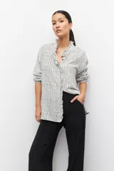 Pantalón de vestir negro de corte ancho y tiro alto, con elástico en la cintura y costuras verticales decorativas a lo largo de las piernas.