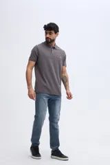 Remera polo verde militar de algodón pima, con cuello y puños acanalados, cierre frontal de tres botones y pequeño bordado de ave en el pecho.