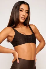 Top deportivo color verde oscuro, con tirantes finos y espalda descubierta. Diseño reversible con un lado brillante y otro con textura 3D tipo colmena.