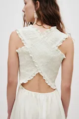 Vestido midi blanco de popelina de algodón, con cuerpo fruncido tipo nido de abeja, escote cuadrado y tirantes anchos con volantes que se cruzan en la espalda. Falda con ligero vuelo.