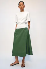 Falda midi de tiro alto, confeccionada en hilatura con mezcla de viscosa, con diseño de rayas verticales en tonos verdes y negros. Presenta corte evasé con bajo acabado y cierre con cremallera oculta en la costura.