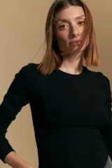 Remera de manga larga en color negro, confeccionada en tejido de punto acanalado con cuello redondo y calce ajustado al cuerpo.