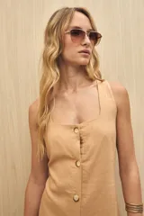 Vestido largo sin mangas color marrón, con escote cuadrado y abotonadura frontal completa. Corte recto con leve abertura en el ruedo.