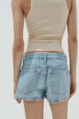 Shorts de denim de tiro medio, color celeste claro lavado, con trabillas, bolsillos laterales y bolsillos de plastrón en la espalda. Cierre frontal con cremallera y botón metálico.