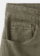 Pantalón cargo de jean color verde militar, de tiro medio, corte ancho y bolsillos laterales con solapa.