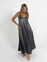 Vestido largo gris de breteles finos y escote en V, confeccionado en tela nacarada.