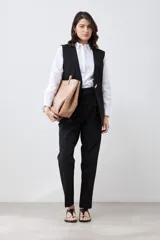 Chaleco largo de corte sastre en color negro, con escote en V, cierre frontal mediante un único botón metálico y diseño sin mangas.