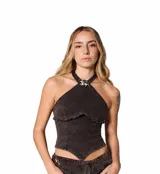 Top halter de denim negro con efecto lavado, corte entallado y espalda descubierta. Presenta recortes frontales estructurados, terminación desflecada en el frente y un aplique metálico decorativo en el cuello.