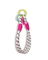 Accesorio decorativo para bolso tipo lazo, confeccionado en cuerda blanca con estampado de pequeños rayos negros. Presenta detalles en hilo fucsia y argollas metálicas en colores amarillo y verde agua, con una etiqueta colgante fucsia.