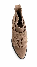 Botinetas de gamuza color marrón oscuro con detalle de flecos en el empeine y correa con tachas metálicas doradas. Poseen suela plana y diseño de caña baja.