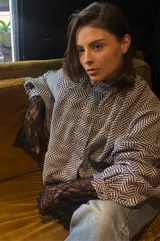 Campera tipo bomber oversize de paño italiano con estampado de espiga en blanco y negro. Presenta cuello alto, cierre frontal con botones metálicos y mangas estilo murciélago.