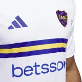 Camiseta de fútbol Adidas del Club Atlético Boca Juniors, modelo alternativo temporada 24/25. Diseño blanco con detalles en azul y amarillo. Incluye logo de Adidas, escudo del club y sponsor Betsson en el frente.