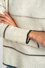 Sweater de punto con diseño de rayas horizontales en tonos neutros, cuello redondo y mangas largas con puños acanalados.