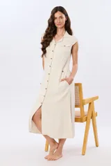 Vestido midi de lino color beige, sin mangas, con cuello solapa, cierre frontal de botones y bolsillos en el pecho.