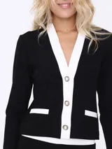 Conjunto de dos piezas compuesto por un saco entallado de manga larga con cierre frontal de botones y solapas en contraste blanco, y un pantalón de corte recto y tiro alto.