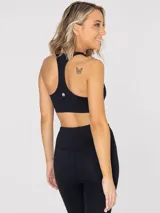 Top deportivo negro de soporte medio, con diseño de espalda estilo nadador y sujetador integrado. Incluye almohadillas removibles.